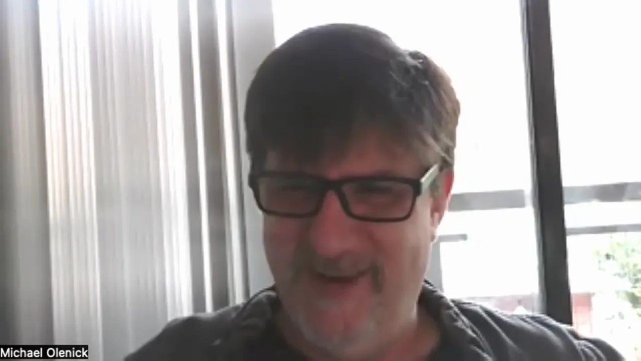 Presenter smiling on a video call with clear framing and a bright windowed background.