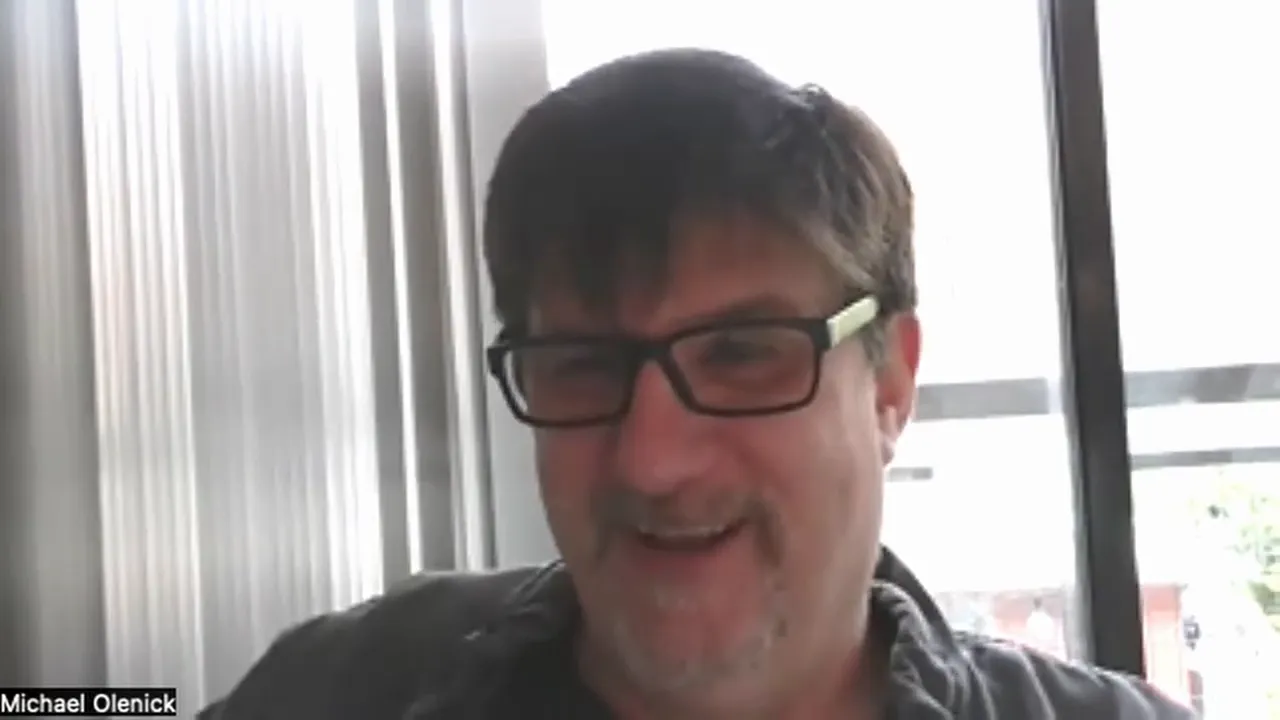 Well-lit video-call screenshot of a presenter smiling, centered in frame with a bright window backdrop; high clarity and approachable expression.