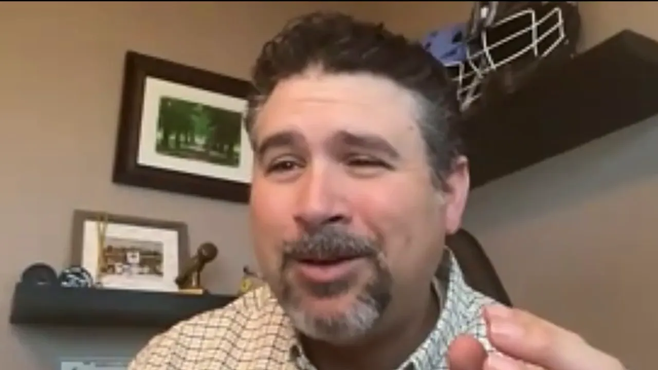 Presenter gesturing while explaining a point about AI and outcomes.