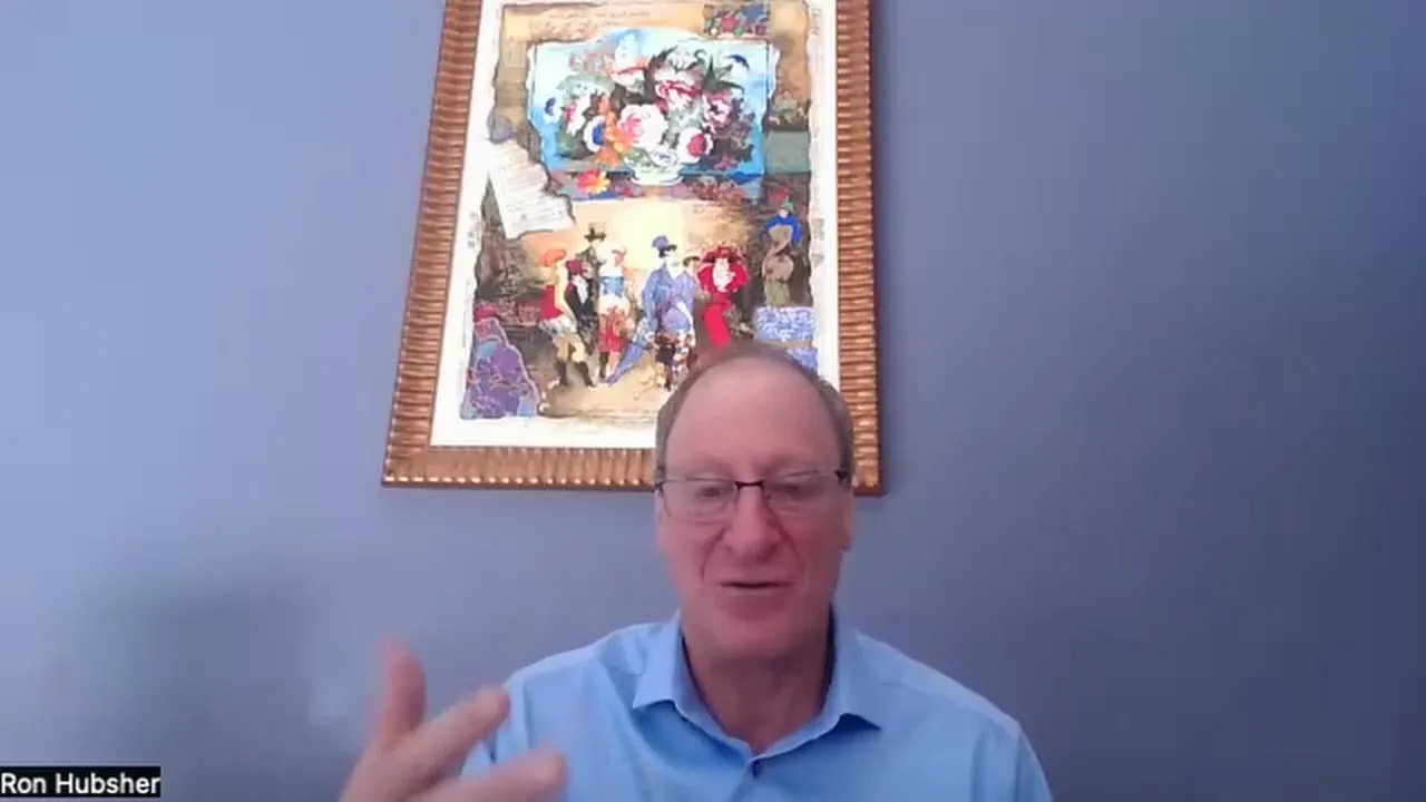 Presenter gesturing with hand in front of framed artwork, explaining prioritization