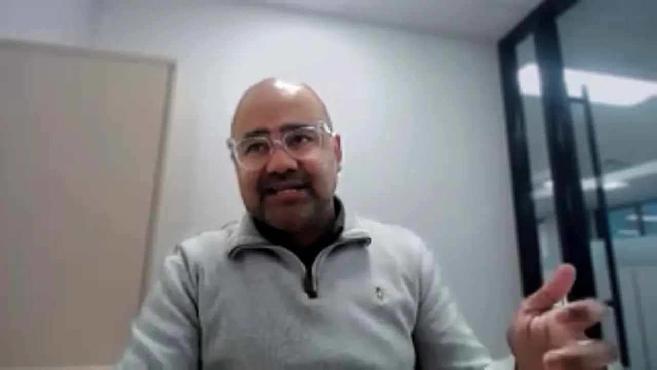 Speaker gesturing while explaining funding strategy in an office