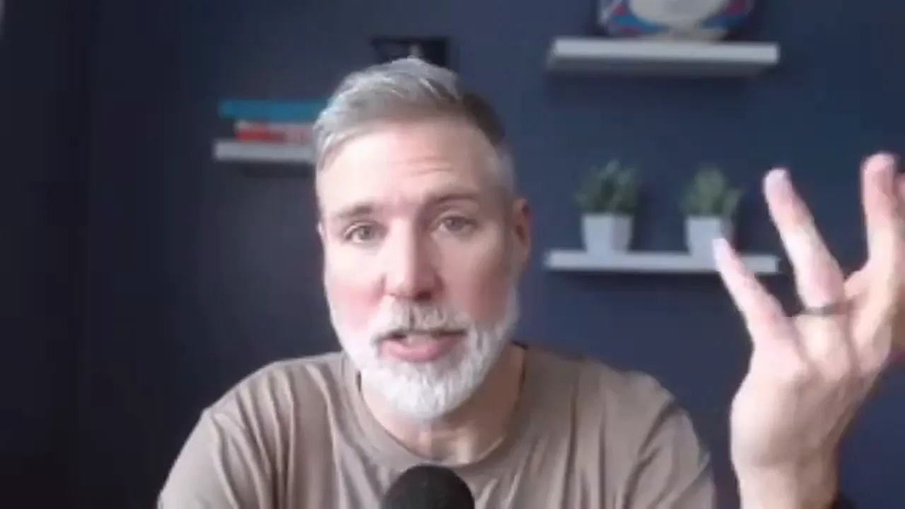 Host facing camera making an open hand gesture while speaking, navy background with shelves and plants visible.