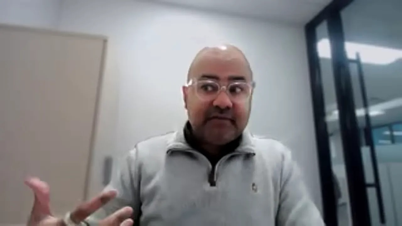 Presenter gesturing while explaining compliance and audit risks in an office video call
