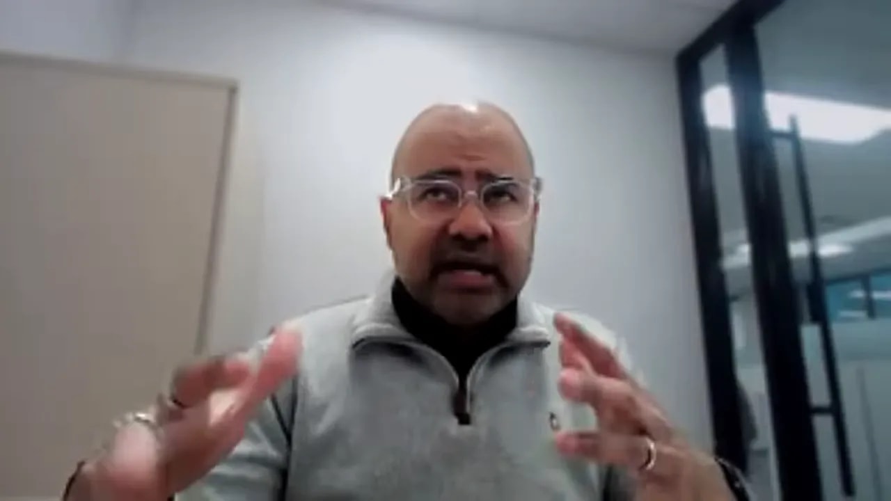 Presenter gesturing with both hands while summarizing key takeaways on non-dilutive funding in an office setting