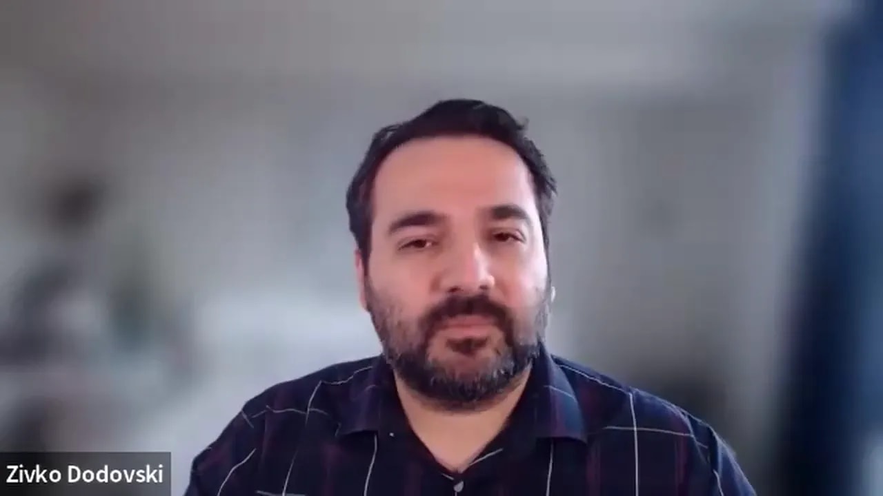 well-lit remote presenter centered on screen with a neutral, blurred background