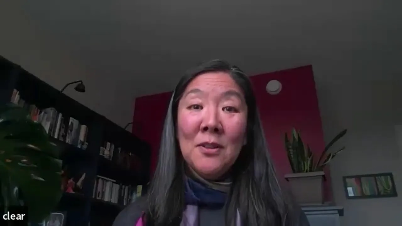 centered head-and-shoulders of a leader speaking on a video call, well-lit with home-office background