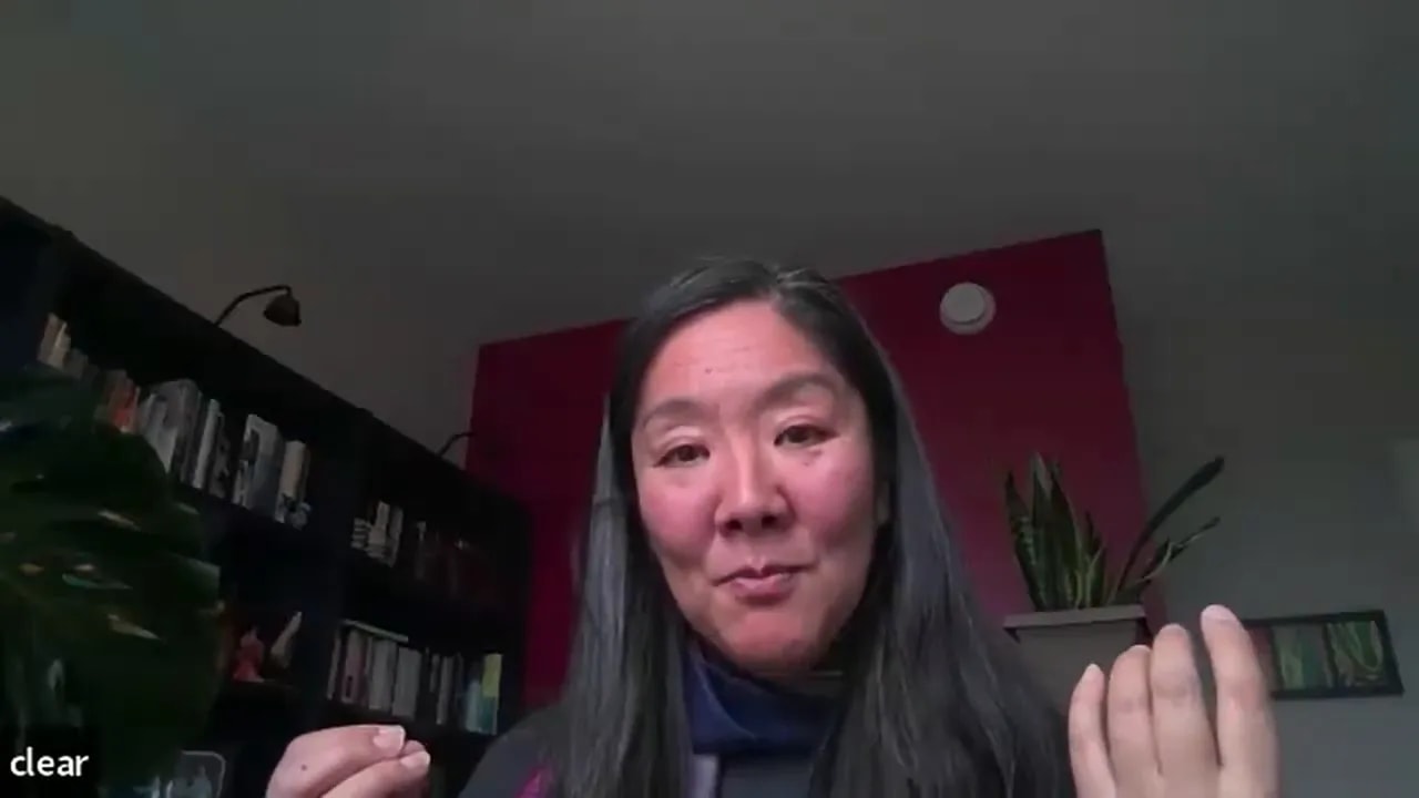 Remote leader on a video call using hand gestures to explain a point in a home office