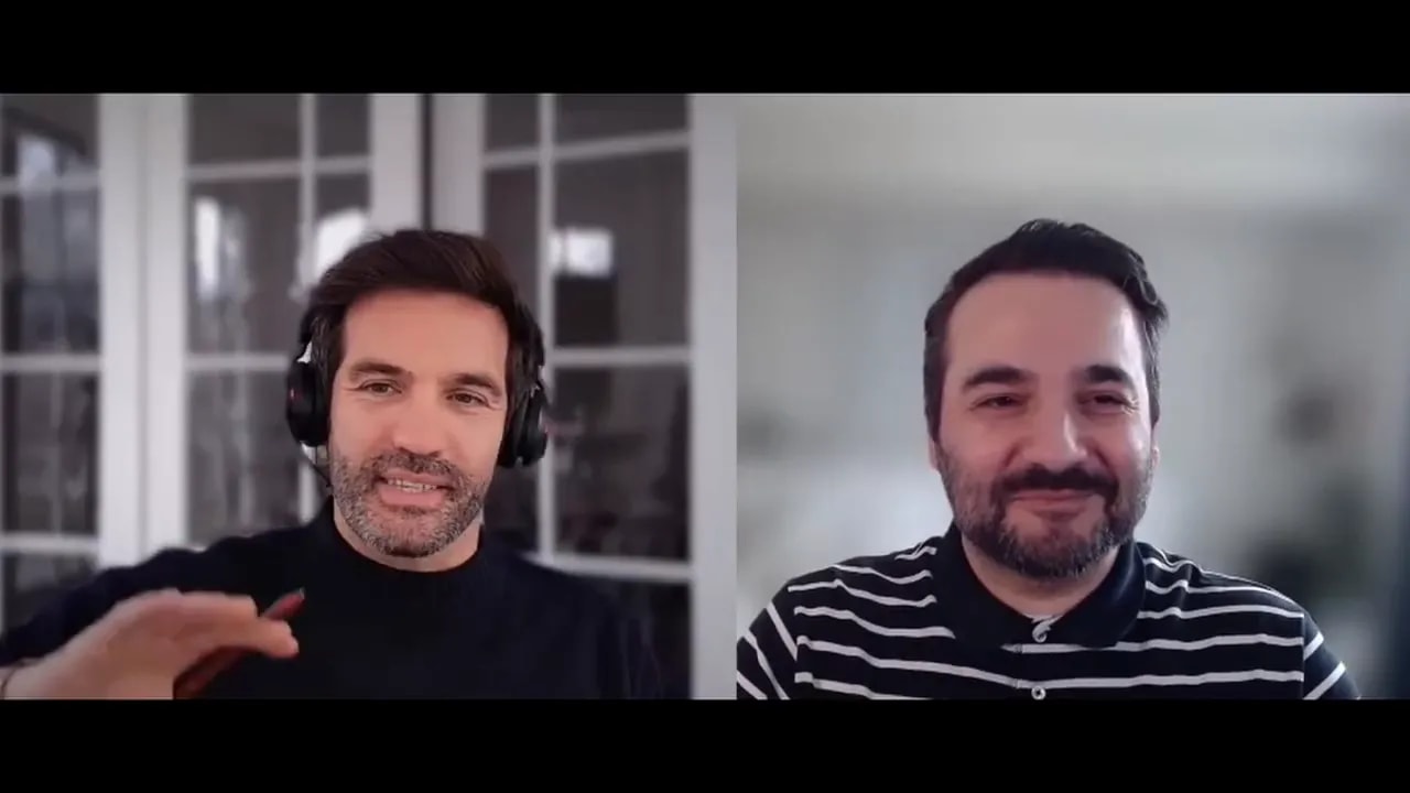 Video interview screenshot of two speakers framing AI as an operating system for workflows