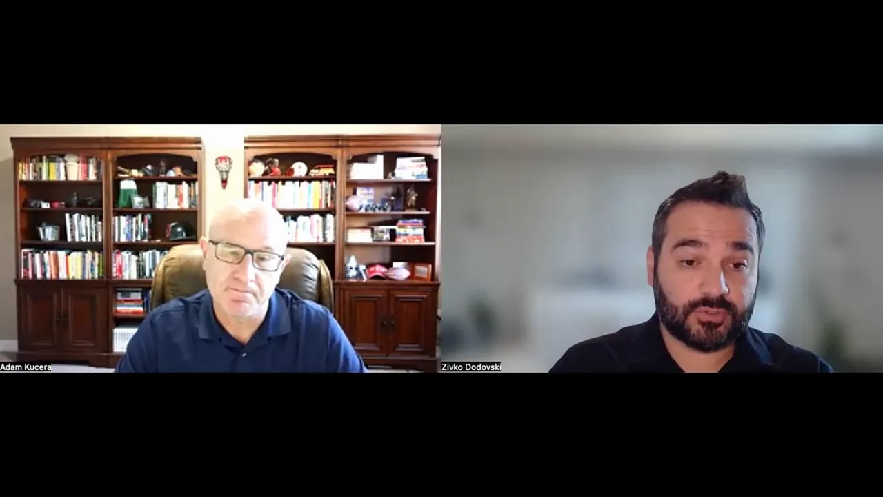 Clear split-screen video call with one speaker in a home office and another in a blurred background, representing a strategic business discussion.