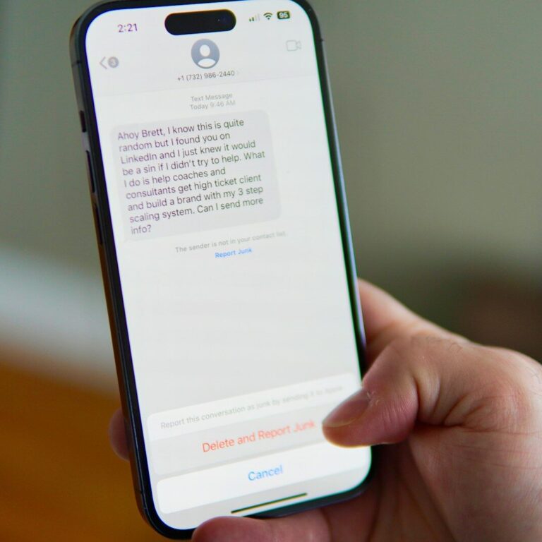 Hand holding a smartphone displaying a text message conversation